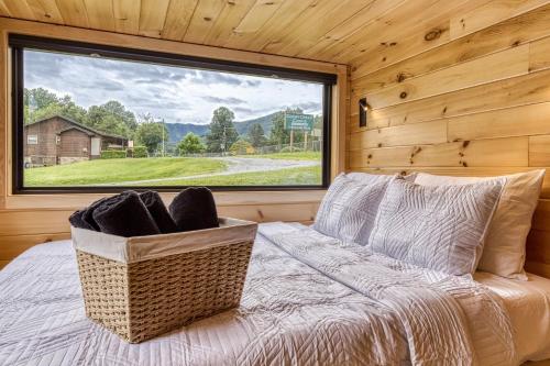 a bed in a room with a large window at Smoky Nook Soak and Smores Getaway in Cosby