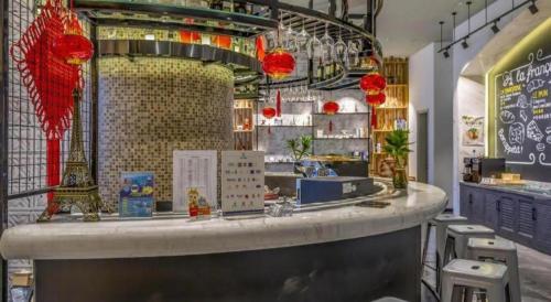 a restaurant with a counter with red lanterns on it at Campanile Hotel Dongying Financial Port in Dongying