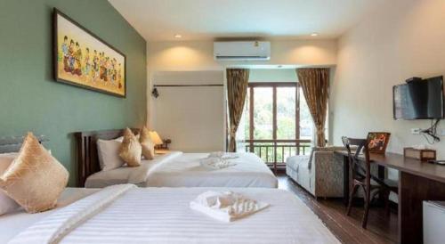 a hotel room with two beds and a desk at The La-Ngu Boutique in Langu