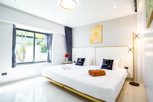 a bedroom with a large white bed with a window at New! bayfront 2 BR Villa with private pool Nariya V1 - rare find in Phuket in Ban Bang Chak