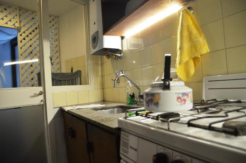 a kitchen with a sink and a pot on a stove at De la calle 45 in La Plata