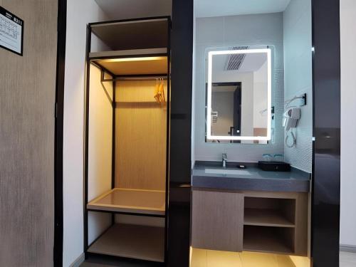 a bathroom with a sink and a mirror at GreenTree Inn Express Fuzhou Linchuan District Gandong Auto City in Shiliting