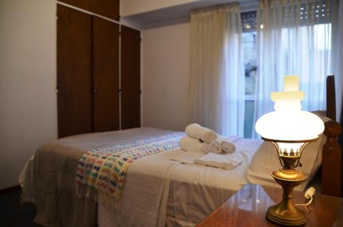 a bedroom with a bed with towels and a lamp at De la calle 45 in La Plata