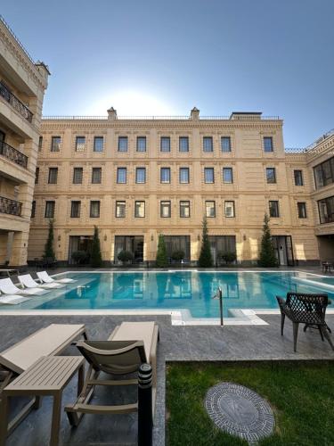 a large building with a swimming pool in front of it at Meridian Plaza by Reikartz in Samarkand