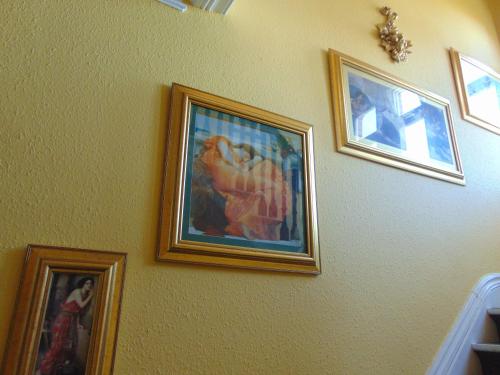 a group of framed pictures on a wall at Holywell House in Loughborough
