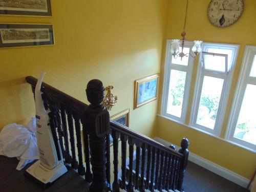 a staircase in a house with a clock and windows at Holywell House in Loughborough