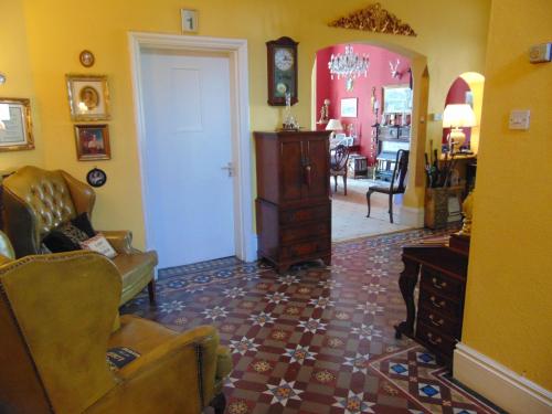 a living room with a chair and a dresser at Holywell House in Loughborough