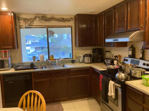 a kitchen with wooden cabinets and a sink and a window at Private house guest rooms in Bellevue, WA in Redmond