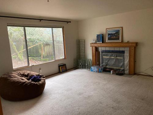 a living room with a fireplace and a large window at Private house guest rooms in Bellevue, WA in Redmond