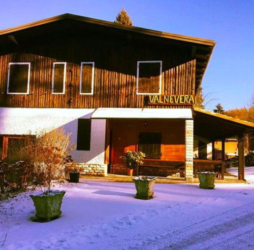 a large wooden building with snow in front of it at Chalet ValNevera in Primolano