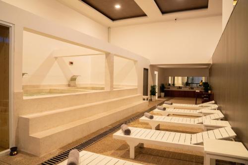 a row of white benches in a room at Royal Beach Resort and Residence by EHM in Phumĭ Kaôh Ândong Sdéch (2)