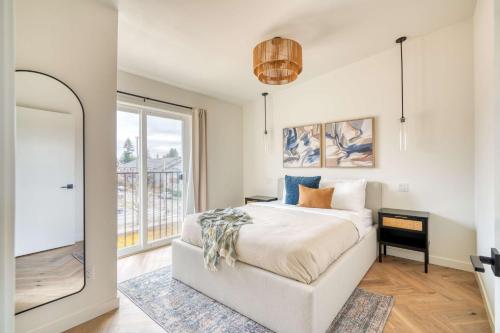 a bedroom with a bed and a large window at Stay Portland - Alberta Arts Escape - Modern 3BR Townhome in Portland