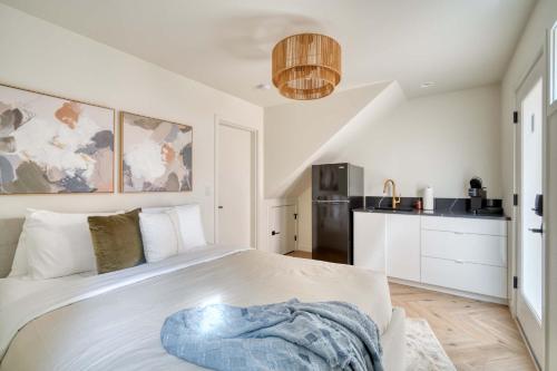 a bedroom with a white bed and a kitchen at Stay Portland - Alberta Arts District Hideaway - Stylish Studio in Portland