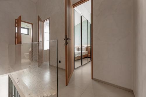 a hallway with a glass door leading to a bedroom at Sunset Bliss Villa with Private Pool-North Canggu in Dalung
