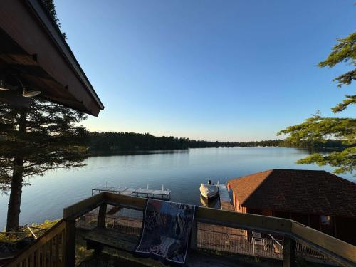a view of a lake with a dock and a house at Private 6-Bdrm Lodge on 1000ft Sandy Lakeshore in Round Lake Seaplane Base