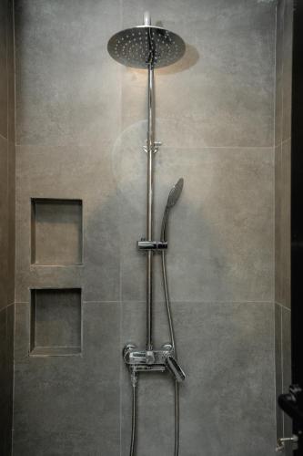 a shower with a shower head in a bathroom at Palm Garden Kuta in Kuta