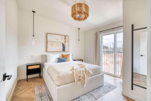 a white bedroom with a bed and a chair at Stay Portland - AlbertaArts Happy Place Townhome - 91 WalkScore in Portland