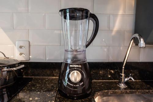 a blender sitting on a counter next to a sink at Brás Downtown Residence Flat in Sao Paulo