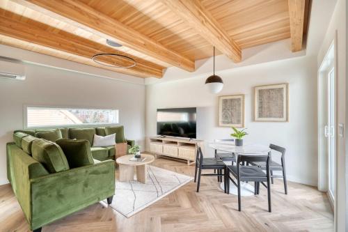 a living room with a green couch and a table at Stay Portland - Alberta Arts District Hideaway - Stylish Townhome in Portland