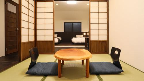 a room with a table and chairs and a bedroom at Liberty Resort 久能宿 in Shizuoka