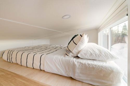 a bedroom with a bed with white sheets and pillows at Stay Portland - The Graffiti Alley Tiny House - Food, Art & Beer in Portland