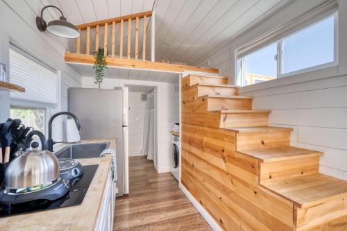 a kitchen with a wooden staircase in a tiny house at Stay Portland - The Tiny Saguaro - Walk to Local Shops & Eateries in Portland
