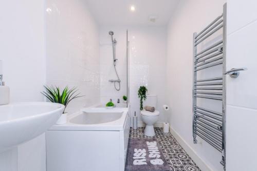 a bathroom with a tub and a toilet and a sink at 4 BDR House By Eason Stays Short Lets & Serviced Accommodation St Helens With Free Parking in Saint Helens