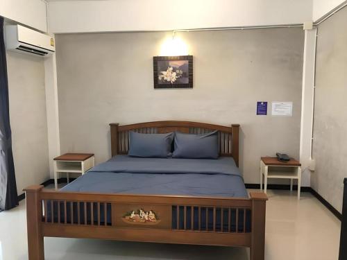 a bedroom with a bed with blue pillows at Kidthuengpark in Ban Nong Faep