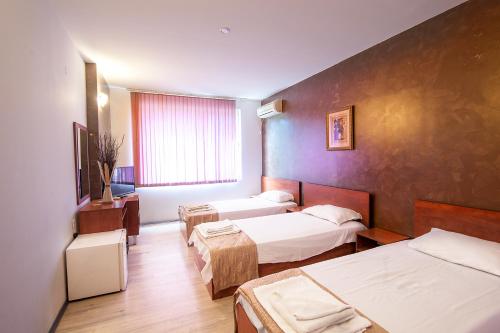 a hotel room with two beds and a window at Hotel Zara Rooms in Stara Zagora