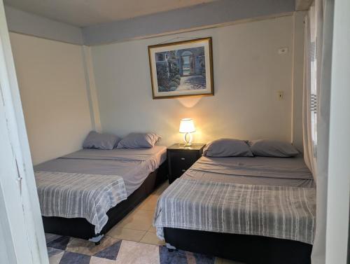 a bedroom with two beds and a lamp on a table at Jacqueline's Court in Mount Pleasant