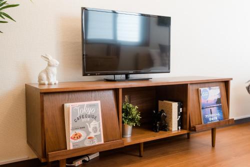 a flat screen tv sitting on top of a wooden shelf at Dash Living Shinjuku in Tokyo
