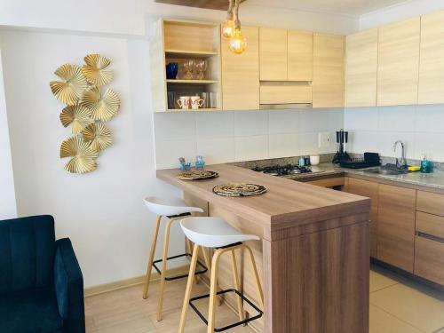 a kitchen with a counter and stools in a room at San Miguel Apartment Ocean Magic in Lima