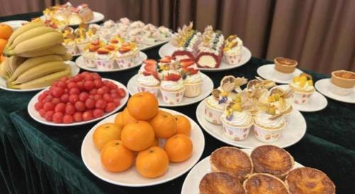a table topped with plates of fruit and pastries at Vienna Hotel Guangxi Liuzhou Sanjiang Gulou Niaochao Passenger Station in Sanjiang