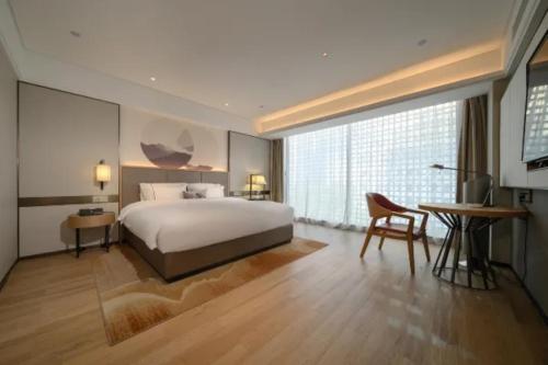 Un dormitorio con una cama, una mesa y un escritorio. en Echeng Hotel Nanning the Mixc Convention, en Nanning