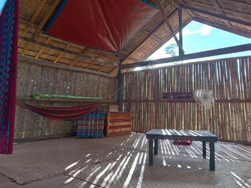 a hammock in a room with a hammock in it at Saneehaa Homestay Resort in Ban Sibouhuang