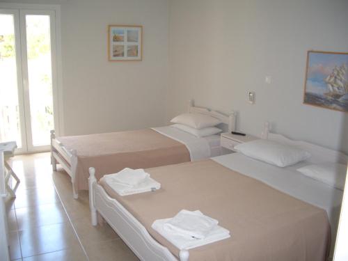 a bedroom with two beds and a window at Hercules Sea Front Studios in Katelios