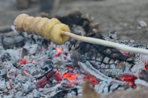 a sausage on a stick over a fire at Saneehaa Homestay Resort in Ban Sibouhuang