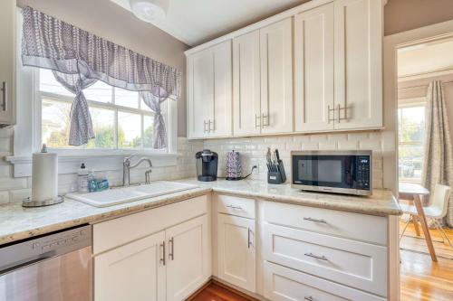 a kitchen with white cabinets and a sink and a microwave at Stay Portland - Charming Portland Home in Hollywood District in Portland