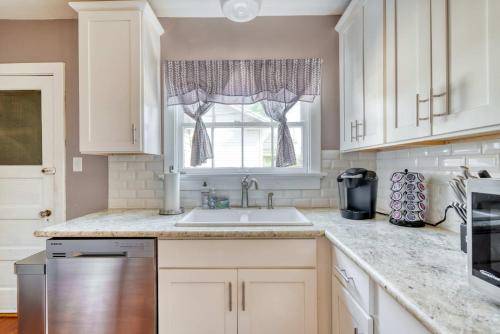 a kitchen with white cabinets and a sink and a window at Stay Portland - Charming Portland Home in Hollywood District in Portland