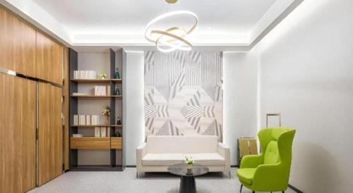 a living room with a couch and a green chair at Borrman Hotel Suzhou Wujiang Zhongshan North Road Pedestrian Street in Suzhou
