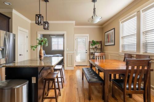 a kitchen and dining room with a wooden table and chairs at Stay Portland - The Garfield Getaway House- Luxury New Build in Portland