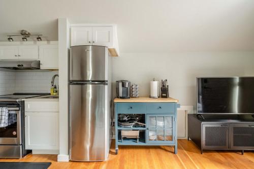 a kitchen with a stainless steel refrigerator and a blue cabinet at Stay Portland - Cozy Attic Hideaway in Laurelhurst in Portland