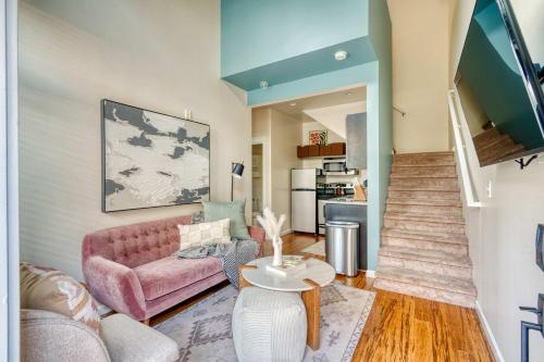 a living room with a pink couch and a table at Chic Loft Retreat in the Heart of NW Portland in Portland