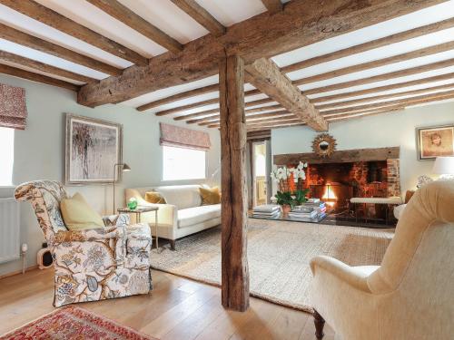 a living room with chairs and a fireplace at Lynchets Cottage in Lambourn