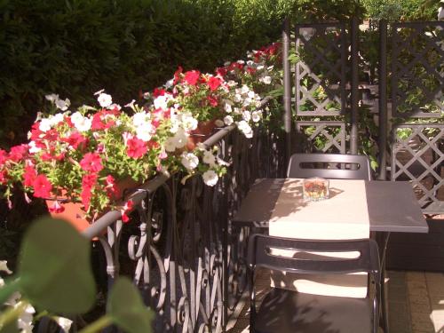 a table and chairs with flowers on a fence at Lucca Relais in Lucca