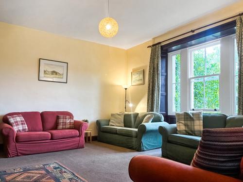 a living room with colorful furniture and a window at High Rylands in Arncliffe