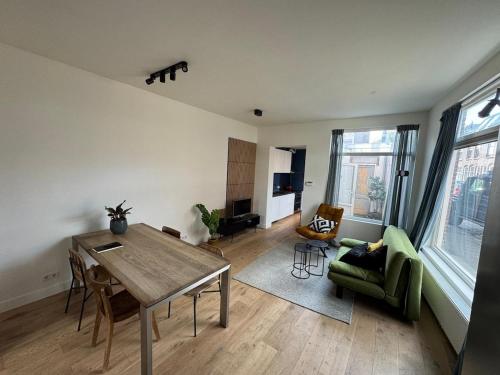 a living room with a wooden table and a green chair at Cozy apartment in Utrecht in Utrecht