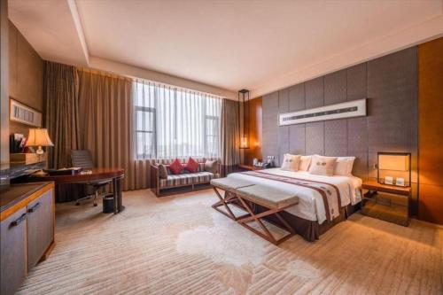 une grande chambre avec un grand lit et un bureau dans l'établissement Chengdu Joyhub Air Hotel, à Chengdu