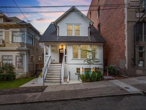 a white house with stairs and a brick building at Stay Portland - Elegant World's Fair 4BR Home 97 WalkScore in Portland