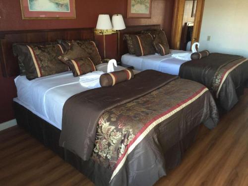 a hotel room with three beds in a room at Americas Best Value Inn & Suites Macon at Sunset Dr in Macon